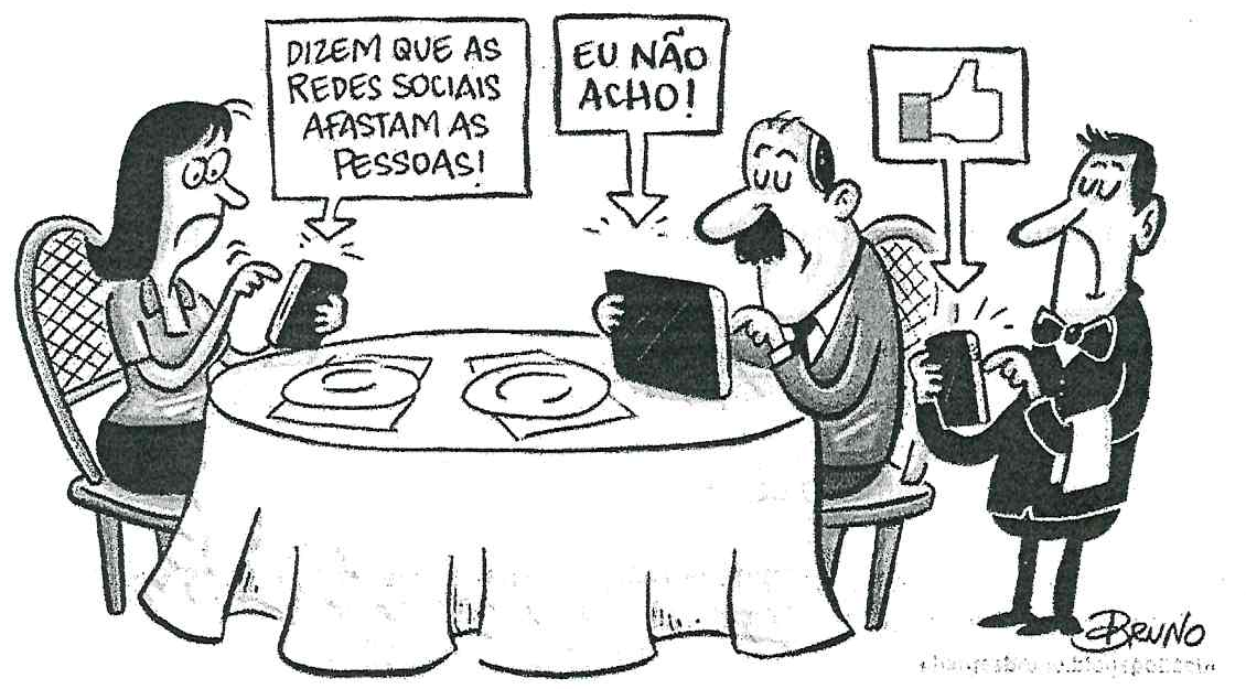 Charge assinada por Bruno. Um casal está sentado a uma mesa de restaurante, cada um olhando para o próprio aparelho. Do celular da mulher sai o balão: “Dizem que as redes sociais afastam as pessoas!” Do tablet do homem sai o balão: “Eu não acho!” Ao lado, um garçom, também olhando o celular, tem acima dele um ícone de “curtir” (polegar para cima).