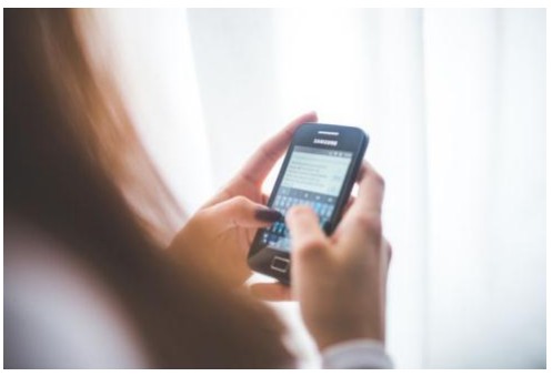 Fotografia ilustrativa de mãos digitando em um telefone celular.