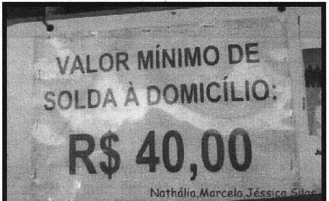 Fotografia de cartaz com os dizeres “VALOR MÍNIMO DE SOLDA À DOMICÍLIO: R$ 40,00” e, abaixo, os nomes “Nathália, Marcela, Jéssica, Sila...”.