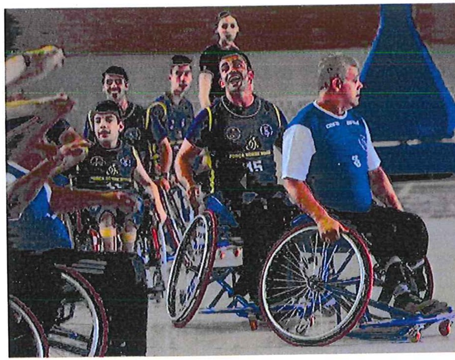 Fotografia de atletas em cadeiras de rodas jogando basquete numa quadra; ao centro, o atleta de número 15.