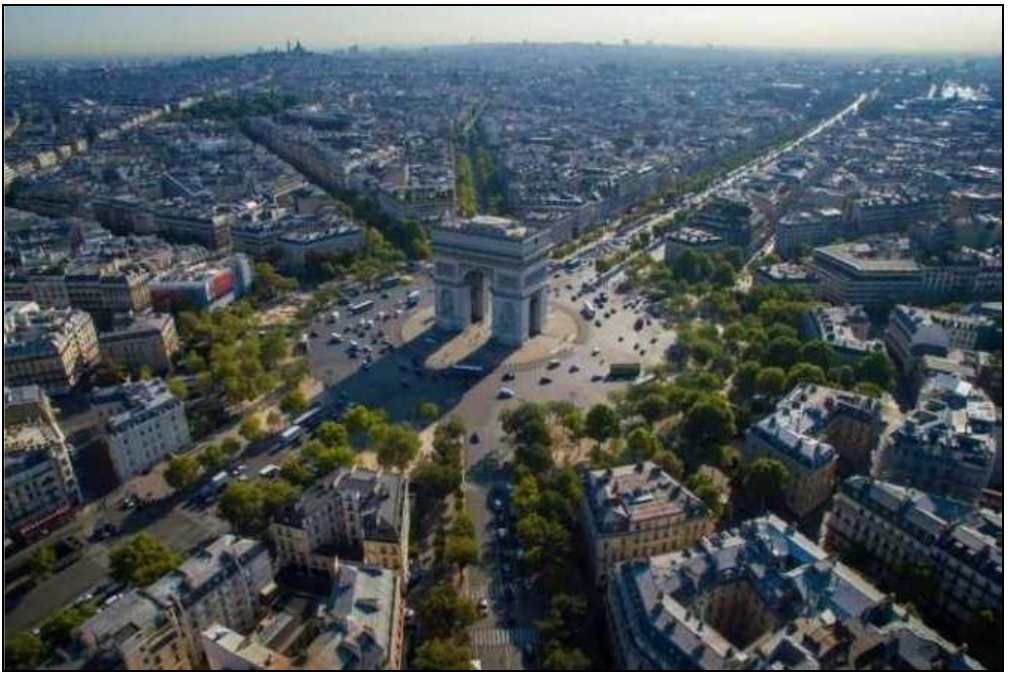 Fotografia aérea de Paris com o Arco do Triunfo ao centro, cercado por avenidas arborizadas e prédios.