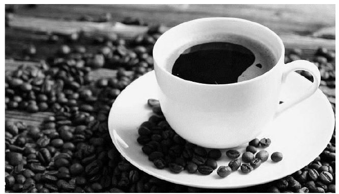 Fotografia de uma xícara de café sobre um pires, cercada de grãos de café.
