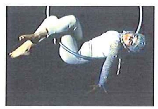 Fotografia de acrobata em traje branco pendurada em um aro (lira) aérea.