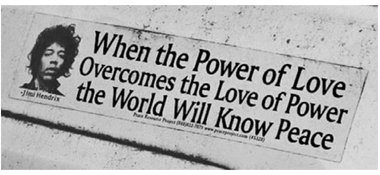Fotografia de um cartaz com o retrato de Jimi Hendrix e a frase: “When the Power of Love Overcomes the Love of Power the World Will Know Peace”.
