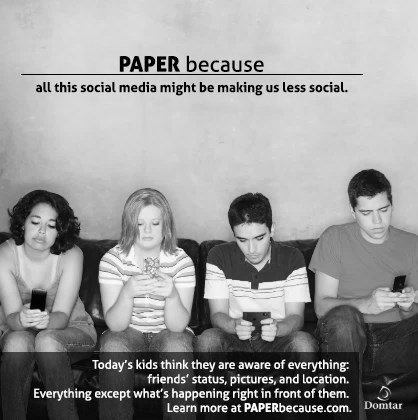 Anúncio publicitário em preto e branco da empresa Domtar. No topo: “PAPER because all this social media might be making us less social.” Abaixo, quatro adolescentes sentados lado a lado em um sofá, cada um olhando para o próprio celular. Na parte inferior: “Today’s kids think they are aware of everything: friends’ status, pictures, and location. Everything except what’s happening right in front of them. Learn more at PAPERbecause.com.” Logotipo da Domtar no canto inferior direito.